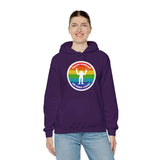 Woman wearing a purple hoodie with a rainbow circle and Sasquatch graphic, celebrating PNW pride and local legends.