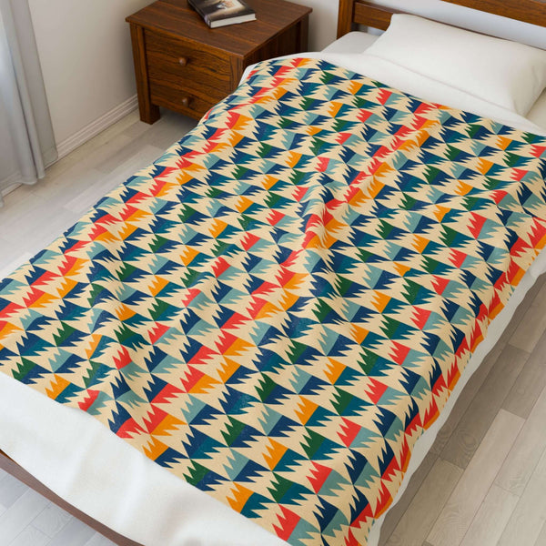 Apres Evergreen in the PNW Retro Lightweight Cozy Blanket with colorful pine tree pattern on a bed.