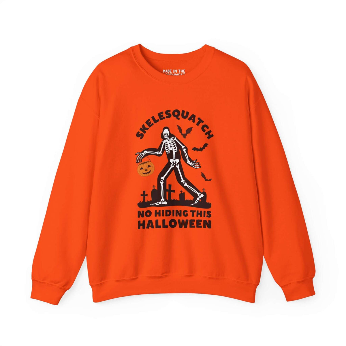 Orange Halloween sweatshirt featuring Skelesquatch with a trick-or-treat bucket, graveyard scene, and text "No Hiding This Halloween".