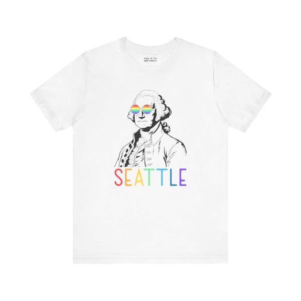 White tee with line art of George Washington wearing rainbow glasses, rainbow "Seattle" text below, celebrating Pride and inclusivity.