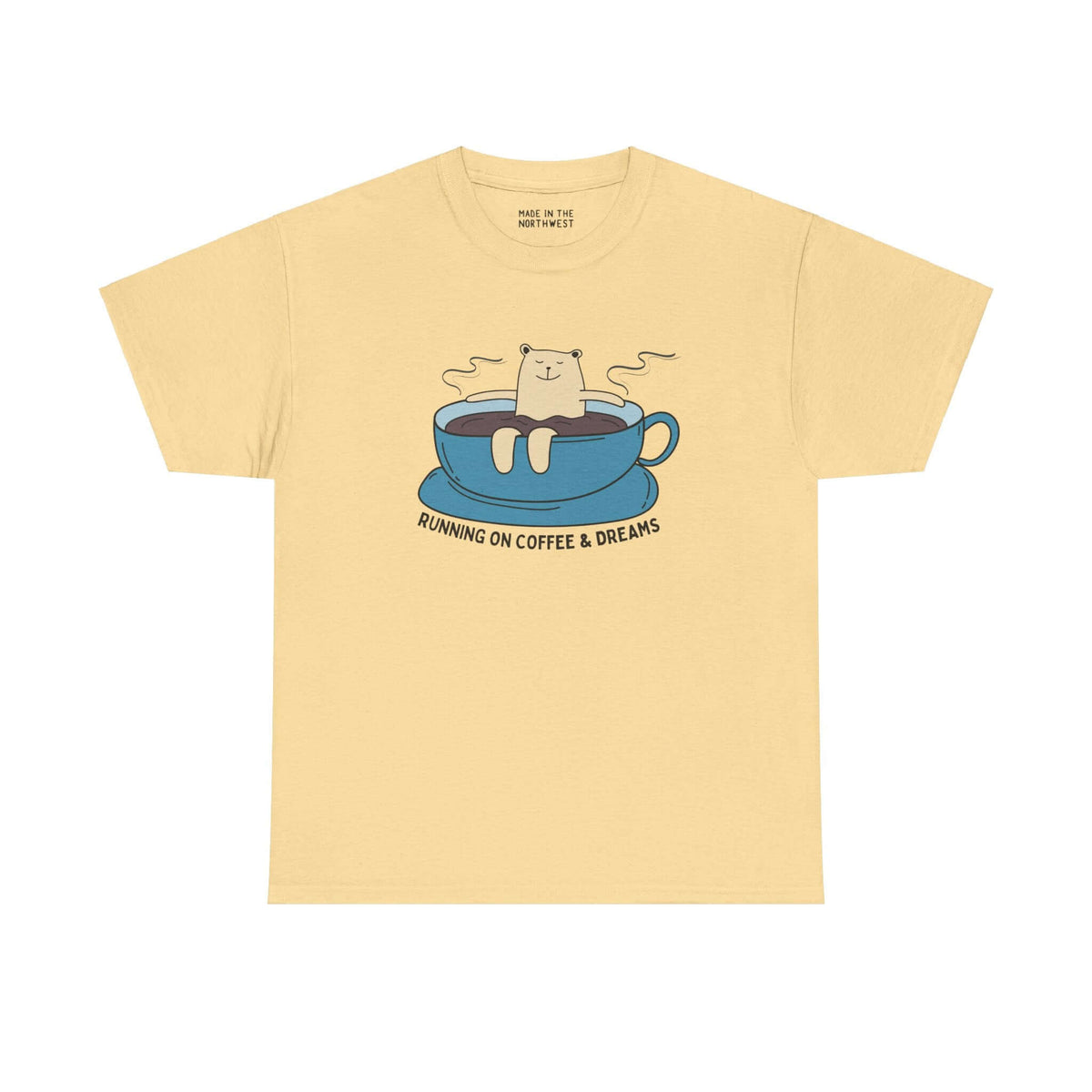 Beige athletic tee with bear lounging in coffee cup, text "Running on Coffee and Dreams" below, ideal for coffee lovers and adventurers.