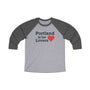 "Portland is for Lovers 3/4 Raglan Tee with heart graphic on gray and black sleeves, celebrating Portland's charm and quirky vibes."