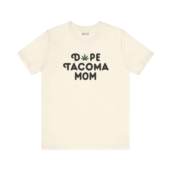 Off-white "Dope Tacoma Mom" tee featuring a playful marijuana leaf design, perfect for cool moms embracing the Tacoma style.