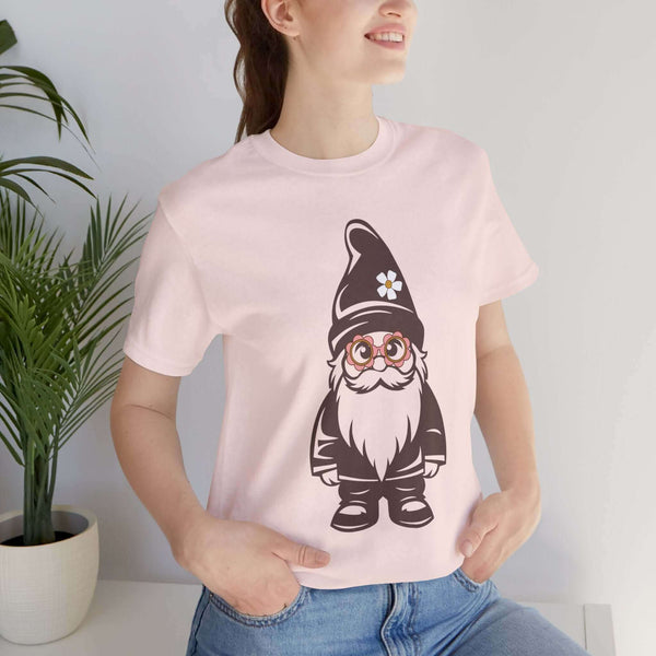 Woman wearing a pink tee with a hippie gnome design featuring daisy glasses and a hat, adding a playful vibe to her outfit.