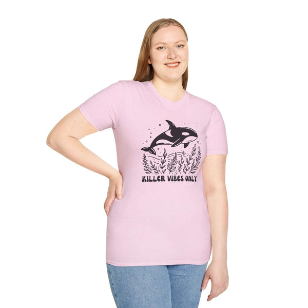 Model wearing Killer Vibes Only Orca Whale Softstyle T-Shirt in pink, featuring a bold orca graphic.