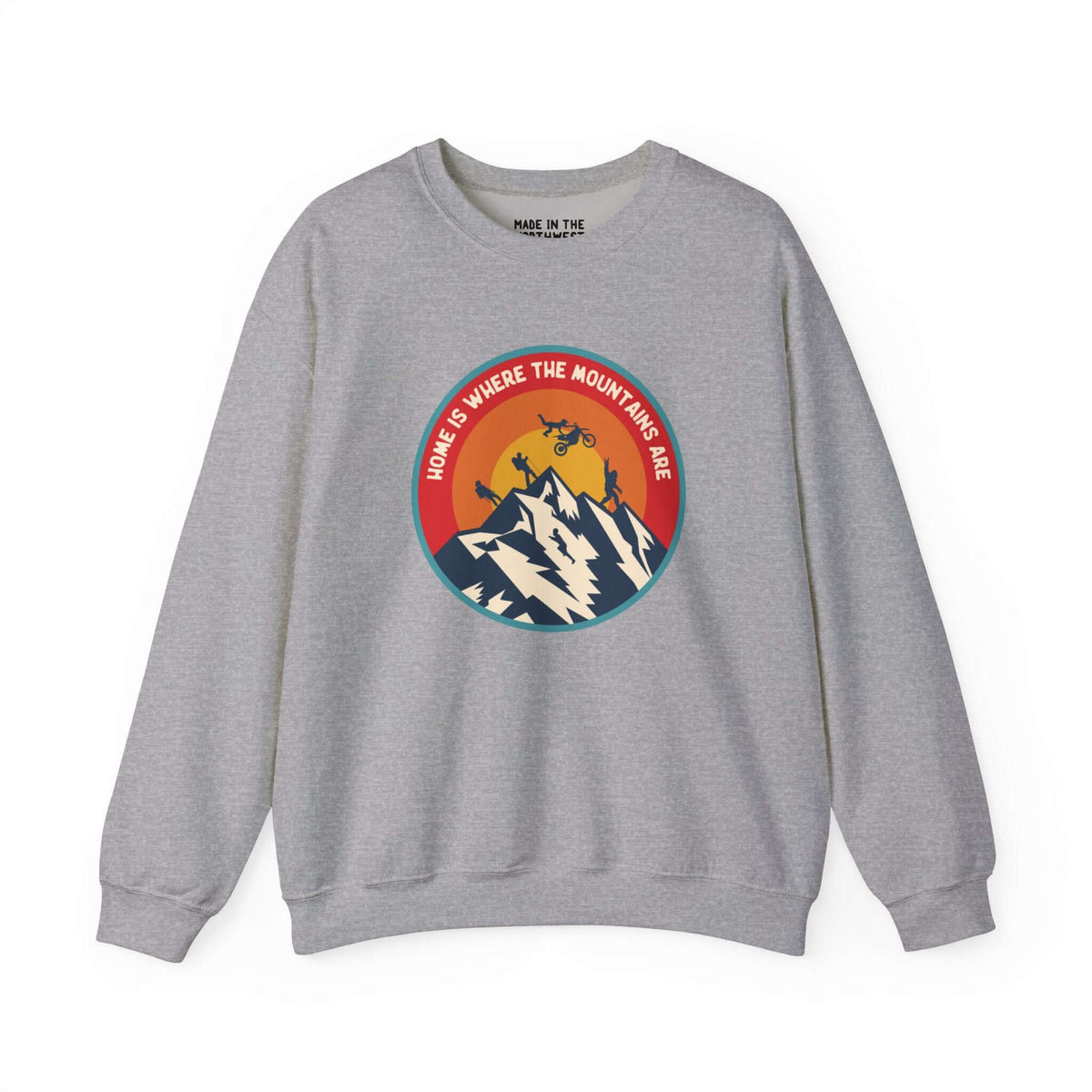 Gray sweatshirt with "Home is Where the Mountains Are" design featuring mountains, motocross, and Bigfoot, celebrating PNW adventure.