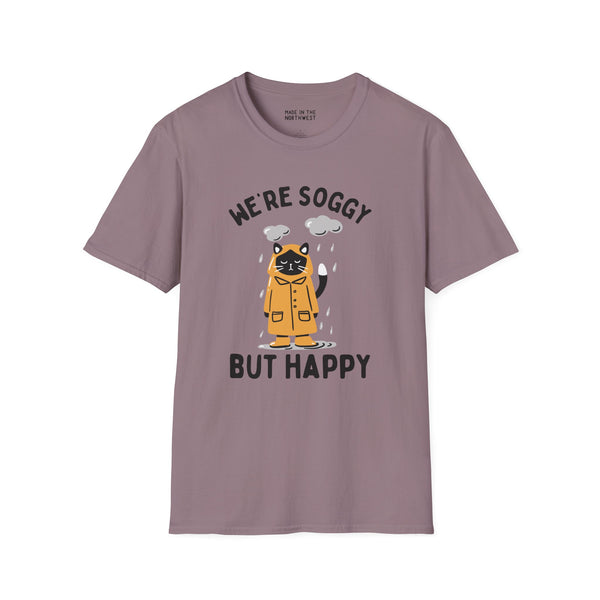 We're Soggy But Happy t-shirt featuring a drenched cat in a raincoat, perfect for embracing rainy days.