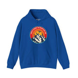 Blue hoodie with 'Home is Where the Mountains Are' graphic, featuring mountains, Bigfoot, hiking, motocross, and a sunset.