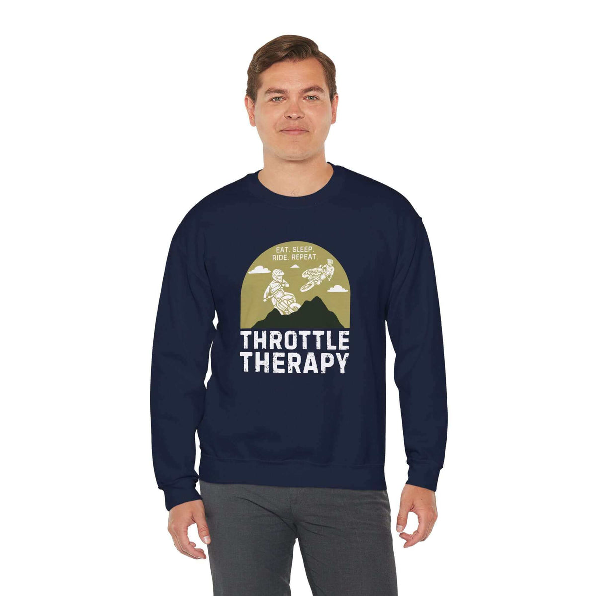 Man wearing Throttle Therapy sweatshirt featuring dirt bikers jumping in front of mountains, ideal for motocross enthusiasts.