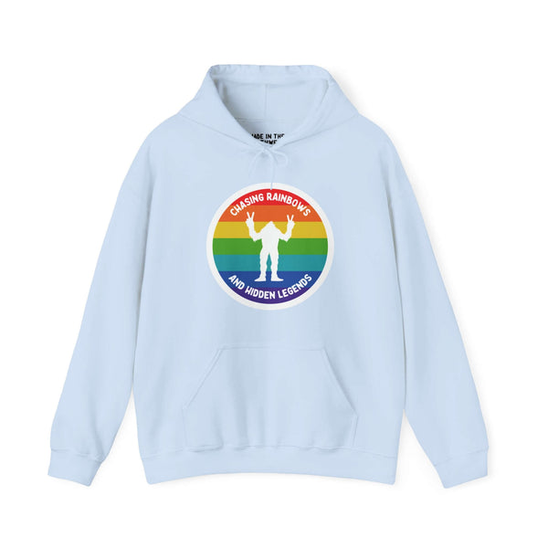 Light blue hoodie with rainbow circle and Sasquatch graphic, text "Chasing Rainbows and Hidden Legends," celebrating PNW pride.