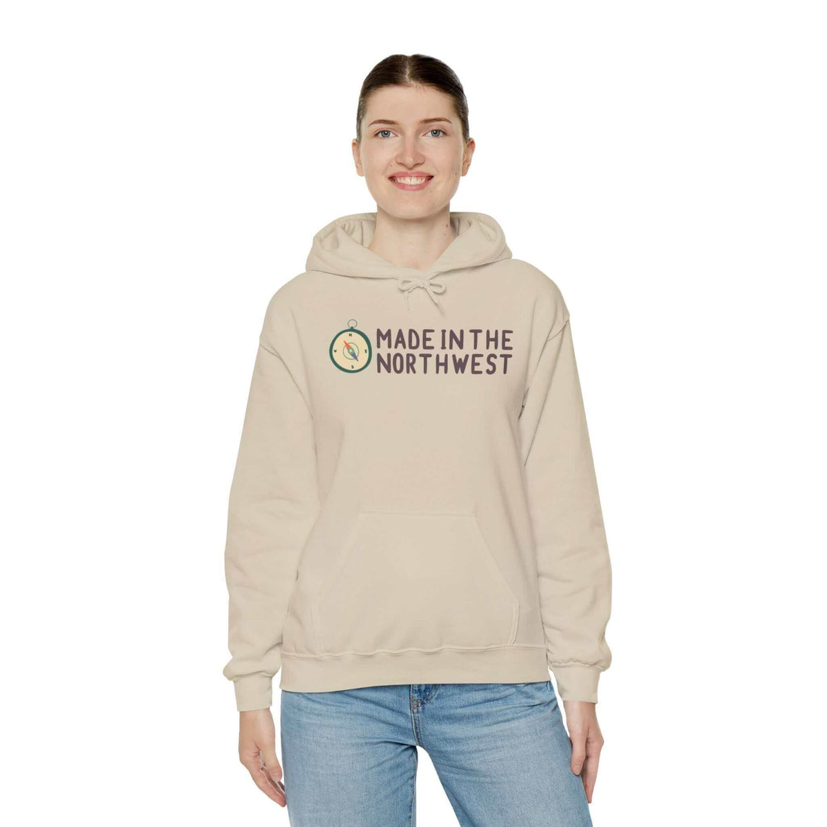 Person wearing Made in the Northwest hoodie with compass logo, showcasing Pacific Northwest pride in beige color.