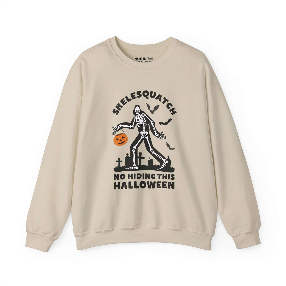 Skelesquatch Halloween sweatshirt featuring skeleton Sasquatch with pumpkin bucket in graveyard, perfect for spooky cryptid fun.