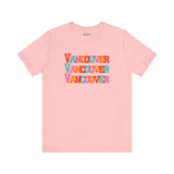 Pink Vancouver trio soft tee with bold, colorful block letters, showcasing vibrant city pride for fans and locals.