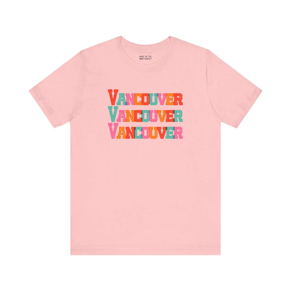 Pink Vancouver trio soft tee with bold, colorful block letters, showcasing vibrant city pride for fans and locals.