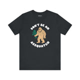 Don’t Be an Assquatch Tee featuring a friendly Bigfoot holding flowers and humorous text.