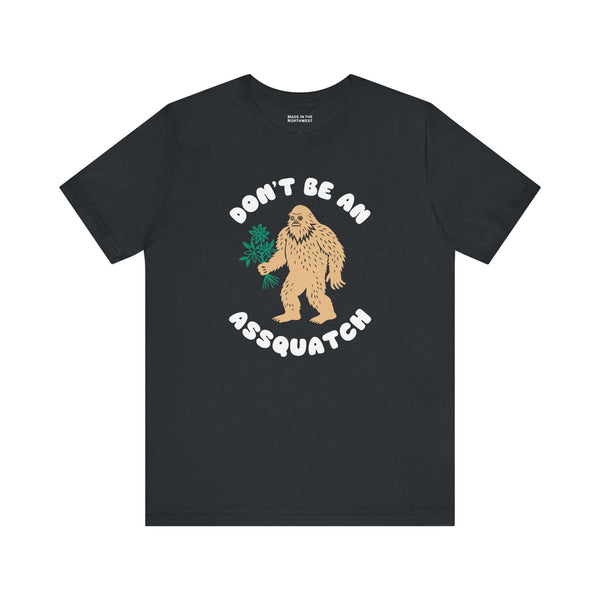 Don’t Be an Assquatch Tee featuring a friendly Bigfoot holding flowers and humorous text.