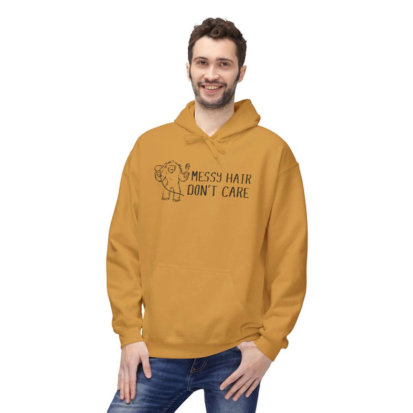 Man wearing a gold Messy Hair Don't Care hoodie featuring a playful Sasquatch graphic.