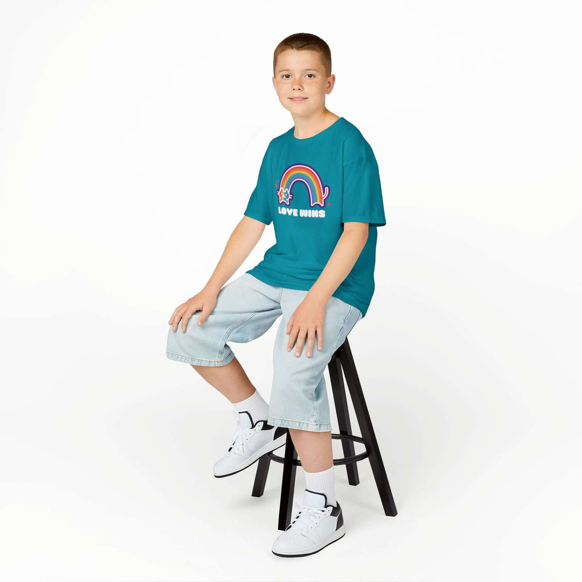 Boy wearing Love Wins Rainbow kids' tee with a cat and rainbow design, spreading joy and kindness.