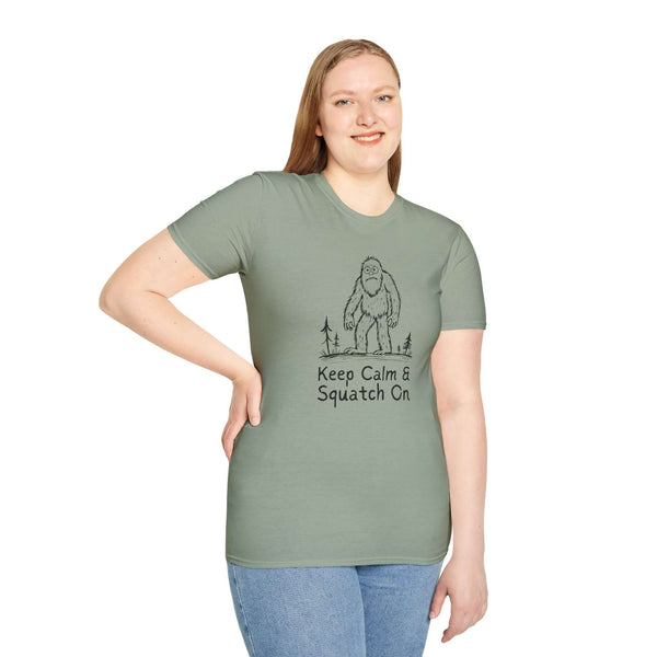 Woman wearing a green Keep Calm & Squatch On Bigfoot t-shirt, showcasing love for Sasquatch and outdoor adventures.