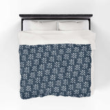 PNW Arrow Crossroads Lightweight Cozy Blanket on a bed, featuring a stylish crossed arrows design.