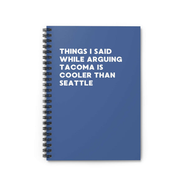 Spiral notebook with blue cover, text: 'Things I Said While Arguing Tacoma is Cooler Than Seattle'