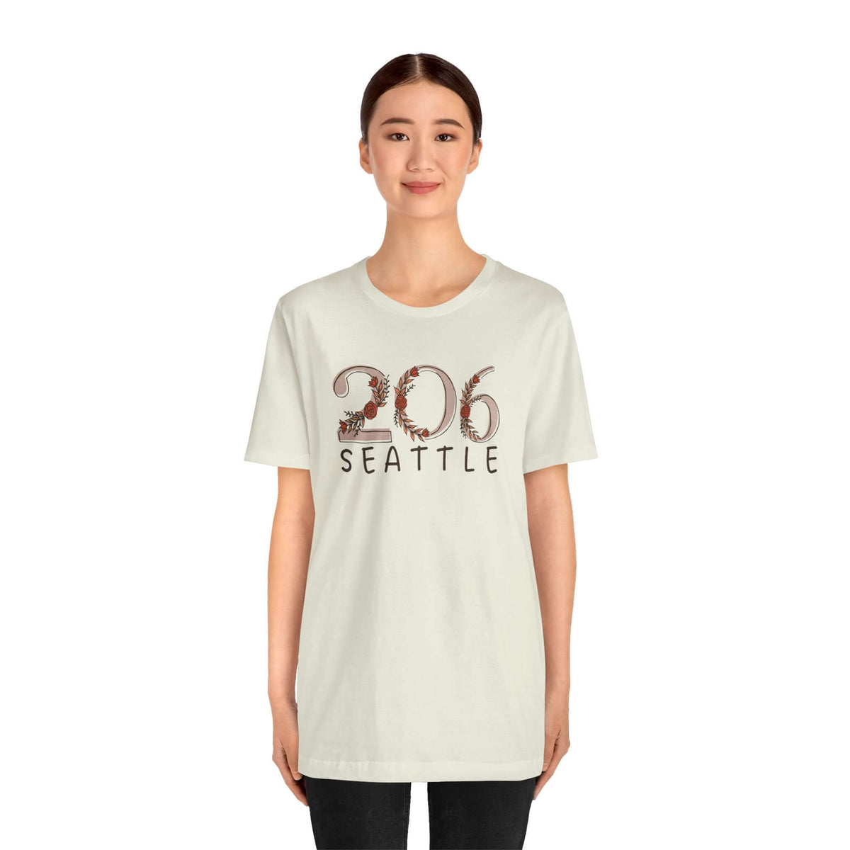 Woman wearing 206 Floral Area Code Premium Soft Tee in light color, showcasing Seattle pride.