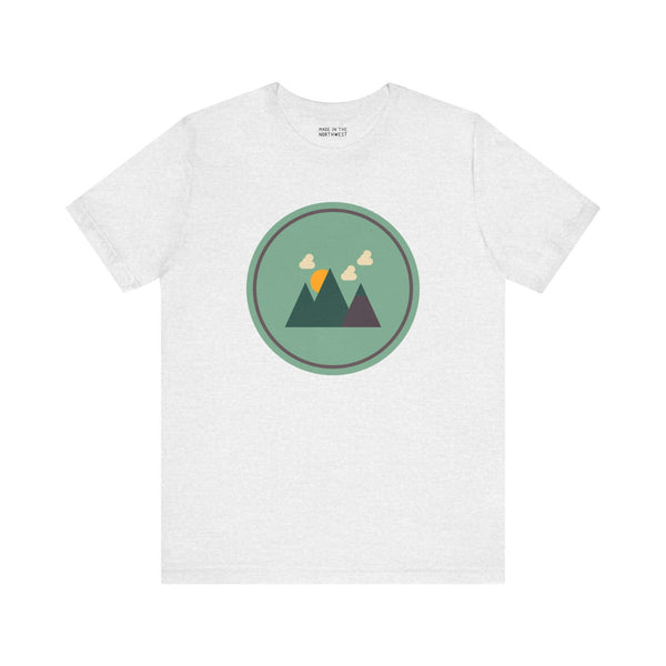 Minimalist forest silhouette tee with mountain design in Northwest style on a soft white shirt.