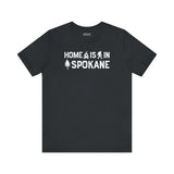 Home Is in Spokane Tee showcasing the phrase and illustrations of campfire, Bigfoot, and a tree.