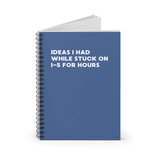 Spiral notebook titled 'Ideas I Had While Stuck on I-5 for Hours' featuring a blue cover.