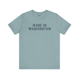 Light blue tee shirt with bold 'Made in Washington' wood log font, representing Pacific Northwest pride.