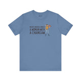Light blue tee featuring the phrase 'Never Underestimate a Woman with a Chainsaw' and an illustrated woman with a chainsaw.