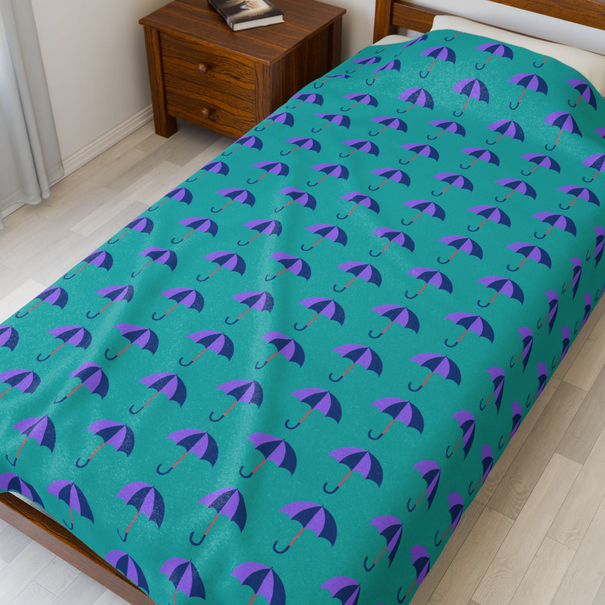Rain & Runways Umbrella Pattern PNW Lightweight Cozy Blanket on a bed with colorful umbrella pattern