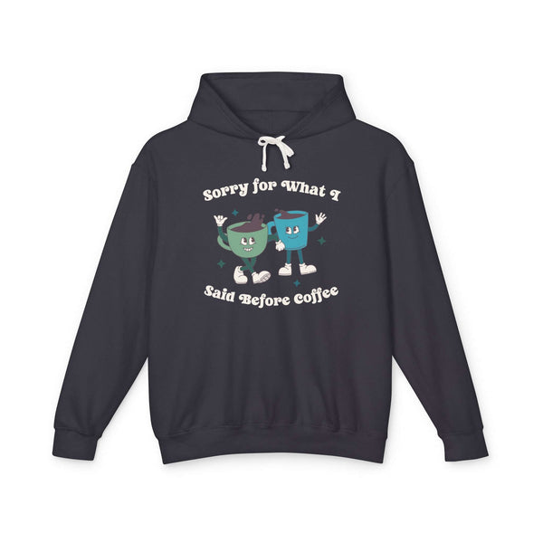 Black hoodie with playful design stating 'Sorry for What I Said Before Coffee' featuring cartoon coffee cups.