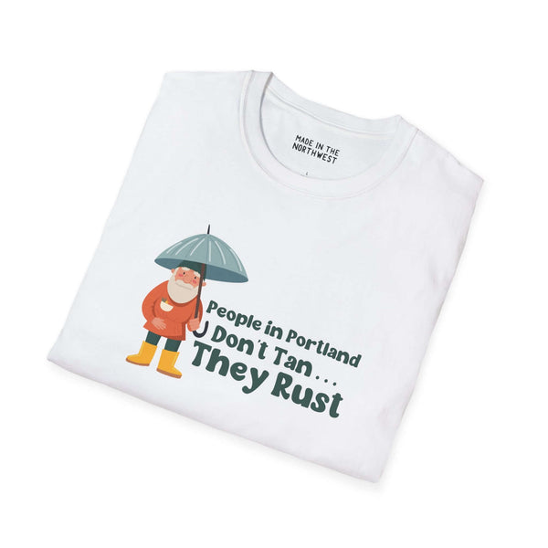 White t-shirt featuring cartoon character with umbrella and slogan 'People in Portland Don't Tan, They Rust'.