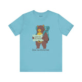 Light blue tee featuring a bear with backpack and map, captioned 