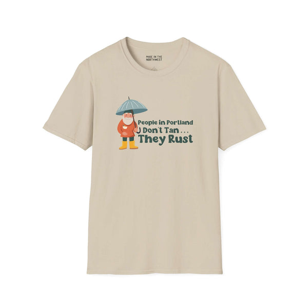 Light beige t-shirt with 'People in Portland Don't Tan, They Rust' graphic design featuring a character with an umbrella.