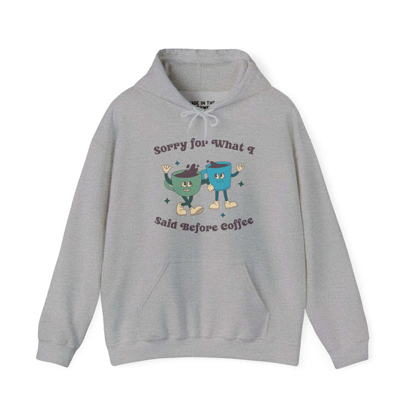 Gray hoodie with "Sorry for What I Said Before Coffee" text and cute cartoon coffee cups, perfect for coffee lovers.