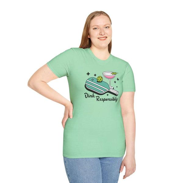Model wearing the Dink Responsibly T Shirt featuring a pickleball paddle, ball, and martini glass.