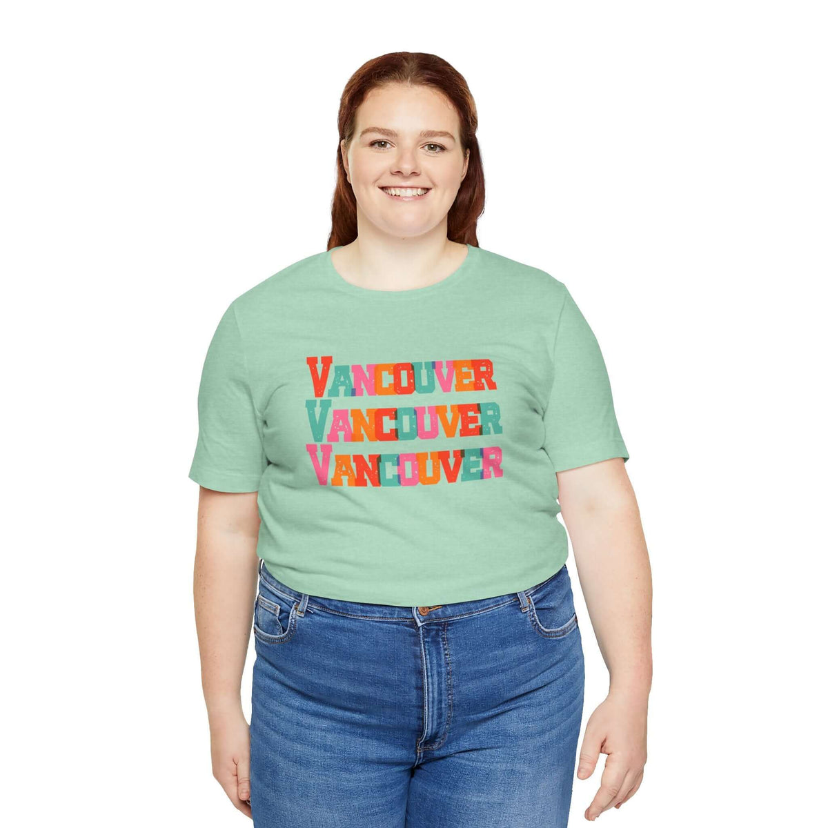 Person wearing a colorful Vancouver soft tee with bold block-letter design, celebrating vibrant city style in a casual setting.