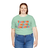 Person wearing a colorful Vancouver soft tee with bold block-letter design, celebrating vibrant city style in a casual setting.