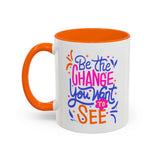 Be the Change You Want to See Mug with colorful hand-lettered design and orange handle.