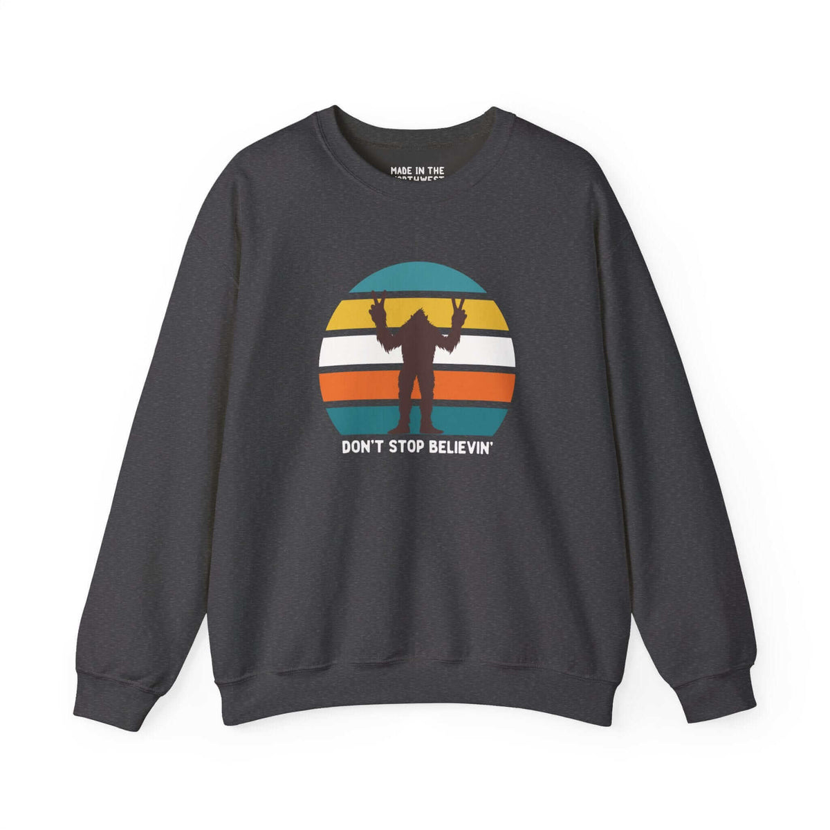 Bigfoot sweatshirt with "Don't Stop Believin'" design and colorful stripes, celebrating Pacific Northwest folklore and adventure.