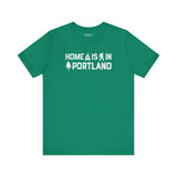 Home Is in Portland Tee – Rose City Pride shirt featuring campfire, tree, and Bigfoot illustrations.