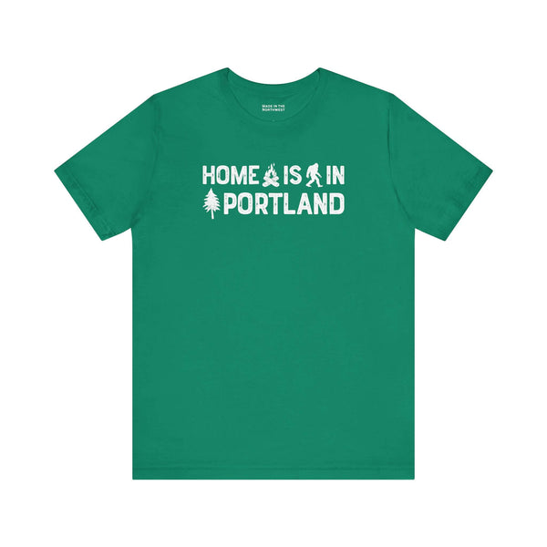 Home Is in Portland Tee – Rose City Pride shirt featuring campfire, tree, and Bigfoot illustrations.