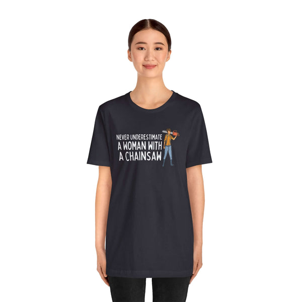 Model wearing a black tee that says 'Never Underestimate a Woman with a Chainsaw'
