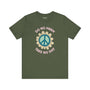 Do No Harm Take No Shit Tee featuring a peace flower design on a green t-shirt.