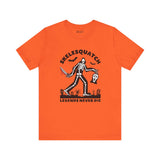 Skelesquatch Halloween tee featuring a skeleton sasquatch with a bloody knife and Scream mask in a graveyard on an orange shirt