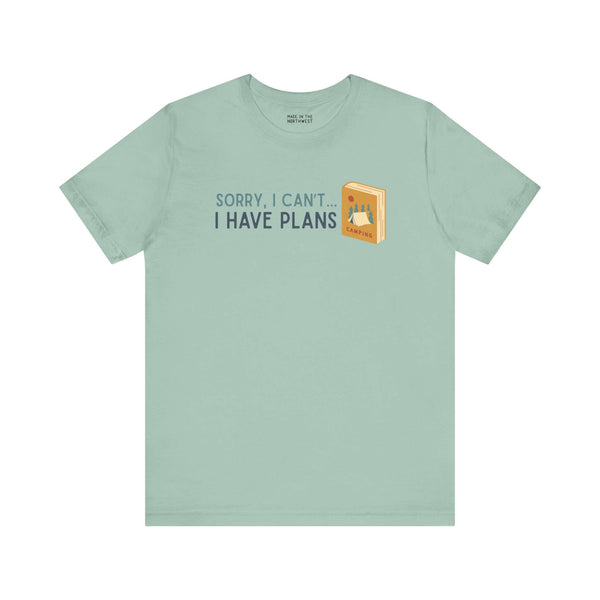 Mint green tee with "Sorry, I Can't... I Have Plans" and a camping book graphic, ideal for outdoor lovers.