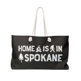 Home is in Spokane Weekender Bag showing campfire, sasquatch, and tree graphics on a stylish tote.