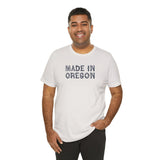 Man wearing a white Made in Oregon log font premium soft tee, showcasing Pacific Northwest pride.